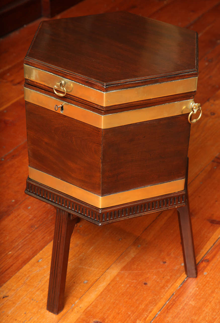 Fine George III Brass Bound mahogany octagonal wine cooler, having a hinged lid with a shaped drop lift handle and a pair of similarly shaped carrying handles to the sides, with zinc lined interior fitted for seven bottles and retaining the original