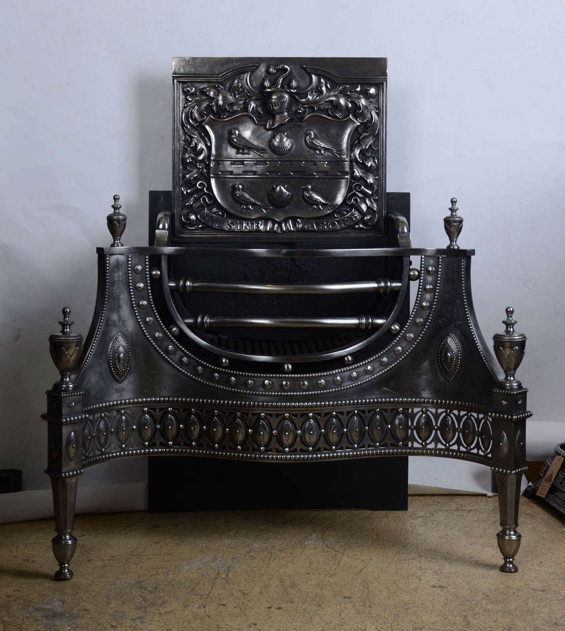 A pair of exceptional antique fire baskets removed from the former Hampstead mansion of Sir Joseph Beecham.

These impressive fire grates are in the neo-classical manner, with railed serpentine baskets, out-swept spandrels and majestic urn finials