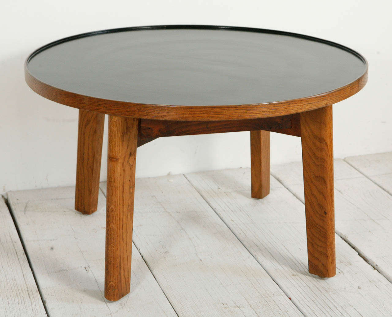 Handsome round oak accent table with black top.