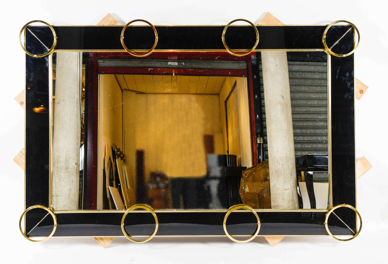 Imposing mirror surrounding with black glass and brass, can be installed in both ways.