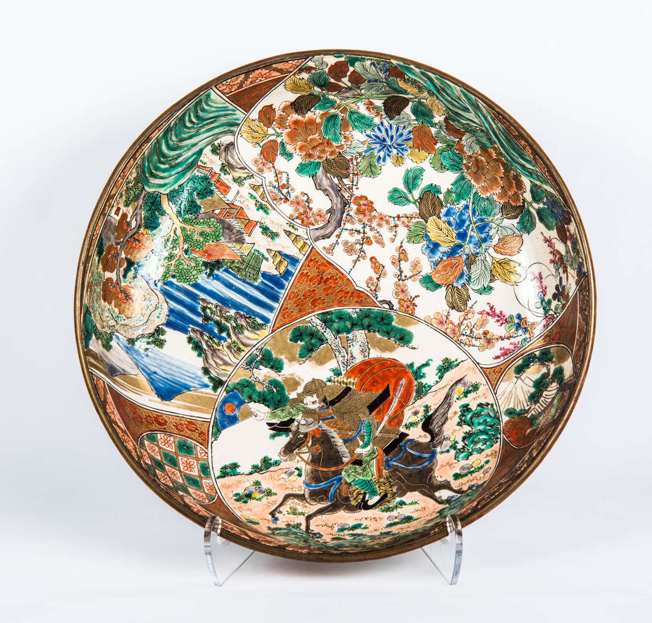 Very large polychrome porcelain dish with horse riding samurai scenery, village in a mountainous landscape and flowering branches.
Branches and flowers decor on the back.
This dish bears the mark of the Kutani Manufacture.
