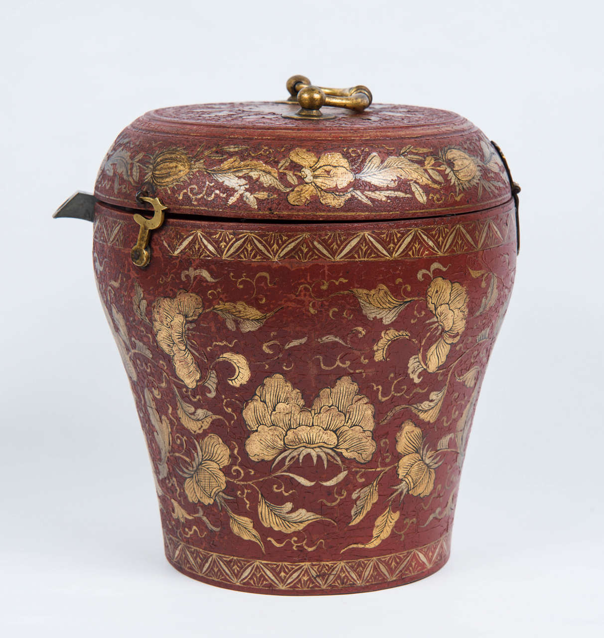 Red lacquer box with a gilt decor of flowers and leaves containing a pewter teapot protected by a padded silk cover.
Small carrying handle on the lid, two small locking hooks. The neck of the pot appears in a small opening made on the front