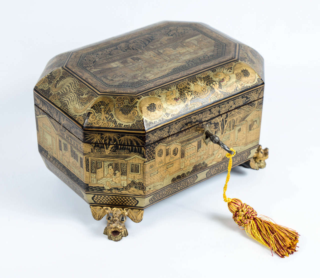 Gilt painted lacquer box on a black background with decoration of characters in palaces. A frieze of dragons on the lid. It stands on two round feet in the back and two feet carved in the shape of bat in front.

China – Canton – Around