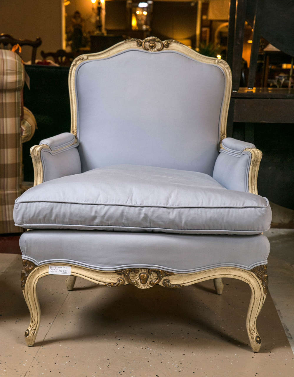 A pair of Louis XV styled down cushioned bergeres in the manner of Maison Jansen. This exquisitely framed and recently upholstered pair of Bergere's having distressed cream with muted gilt gold hi lights. These chairs are downed cushioned with a