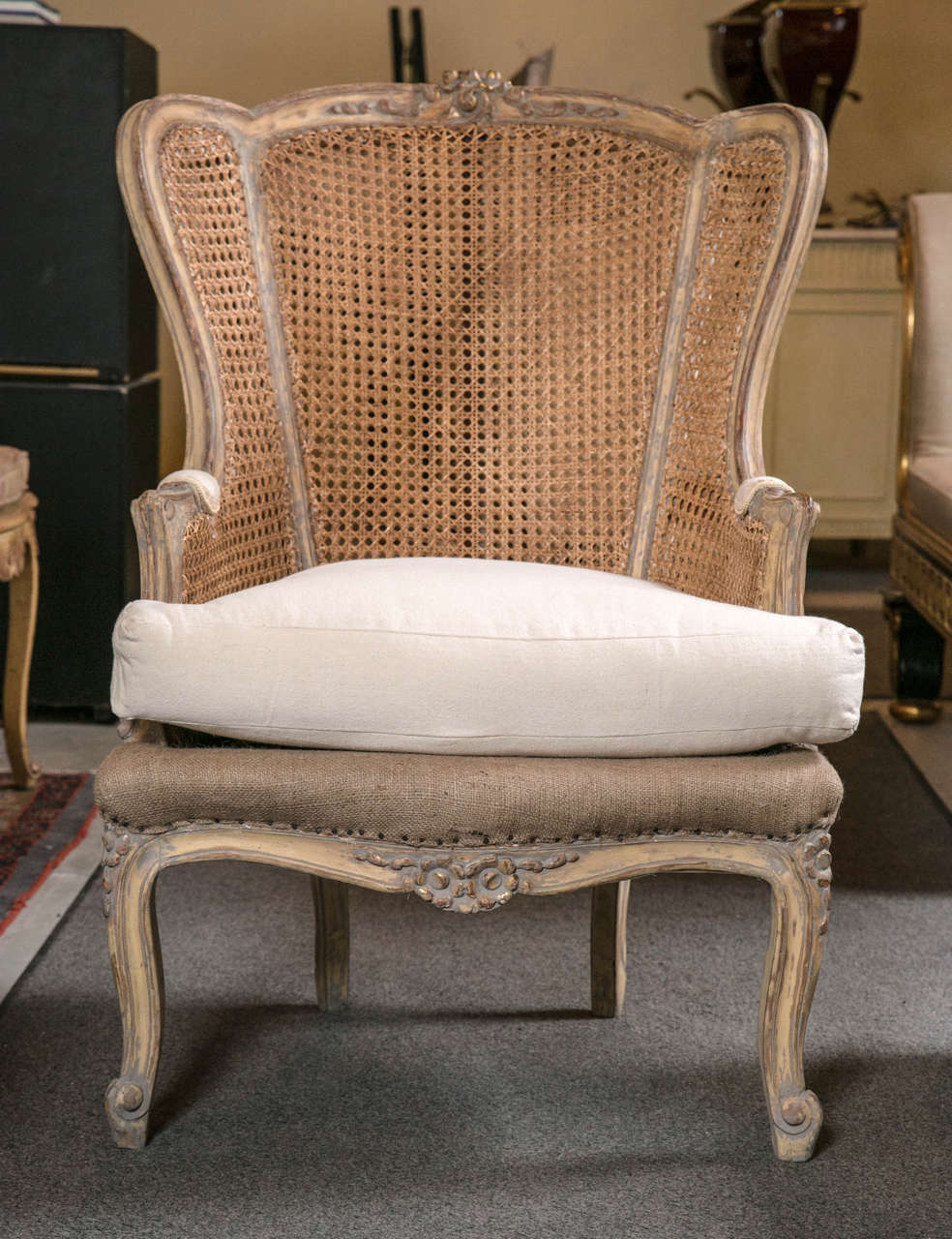 Pair of vintage French Louis XV style caned wingback bergère chairs, circa 1930s, stunning and impossible to find! In original distressed finish with a touch of grey, the slightly domed back flanked by winged sides and padded arms, the back