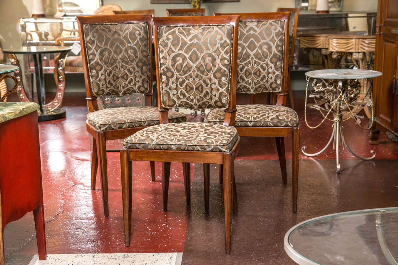 Set of four Art Deco style Mid-Century Modern dining rosewood chairs, circa 1950s, the square shield back with padding joint by a cushioned seat, raised on splayed legs. Overall with beautiful simplicity and style.