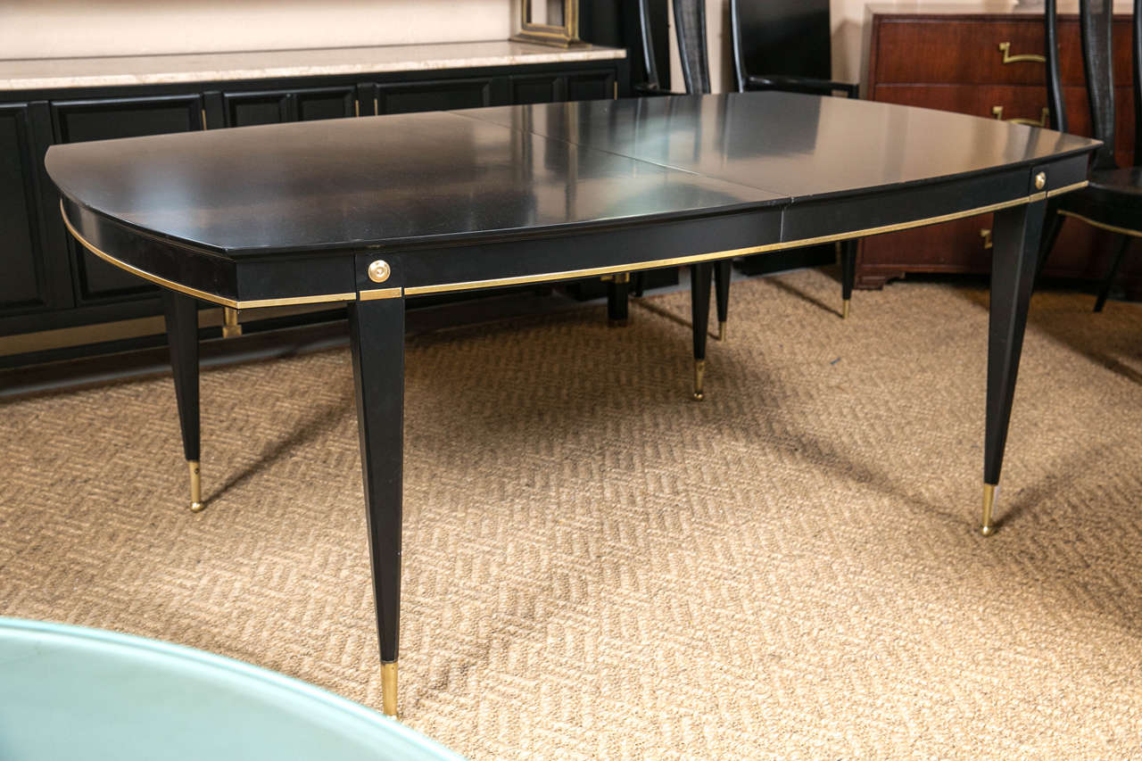 Hollywood Regency at its best Ebonized Dining Table Set manner of Maison Jansen. This fine custom quality dining table sits on brass sabots leading to tapering legs supporting a bronze framed apron with circular bronze corner mounts. The finely