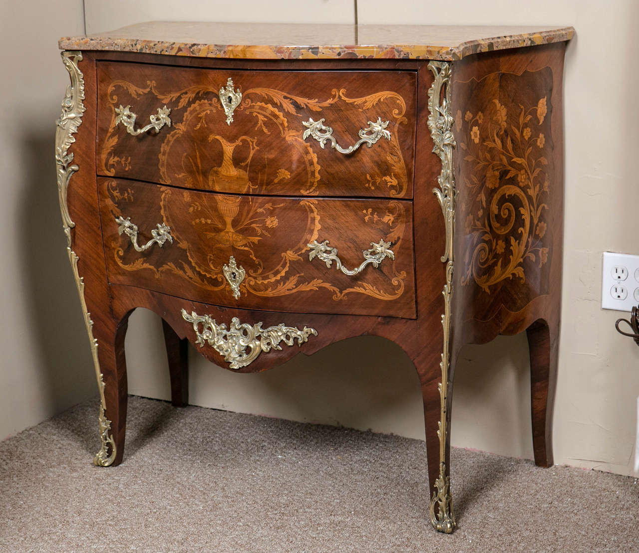 Pair of French Louis XV Style kingwood commodes, circa 1920s, the serpentine shaped marble above a conforming bombe case fitted with two drawers, decorated with elaborate vessel pattern inlays, raised on ormolu mounted splayed legs ending in sabots.