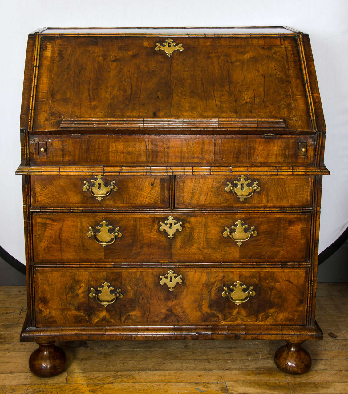 This superb and rare Queen Anne walnut fall front bureau, C. 1710 features the original handles and locks and has the original wax finish. The interior of this beautifully patinaed bureau has two drawers on two levels with pigeon holes above them.