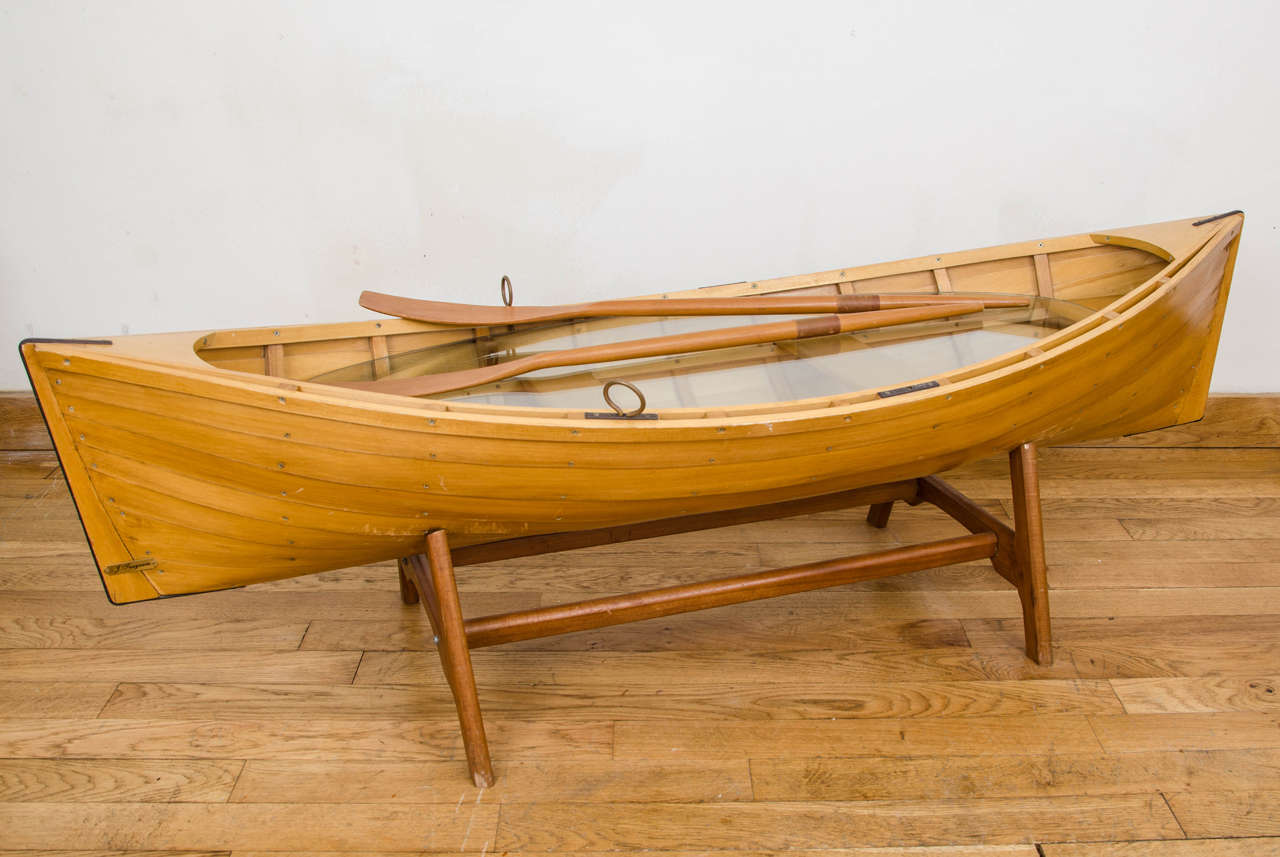 Wooden boat coffee table marked J.Seagram.
It rests on a detachable wooden frame and has a glass insert which is also detachable
Complete with two detachable oars