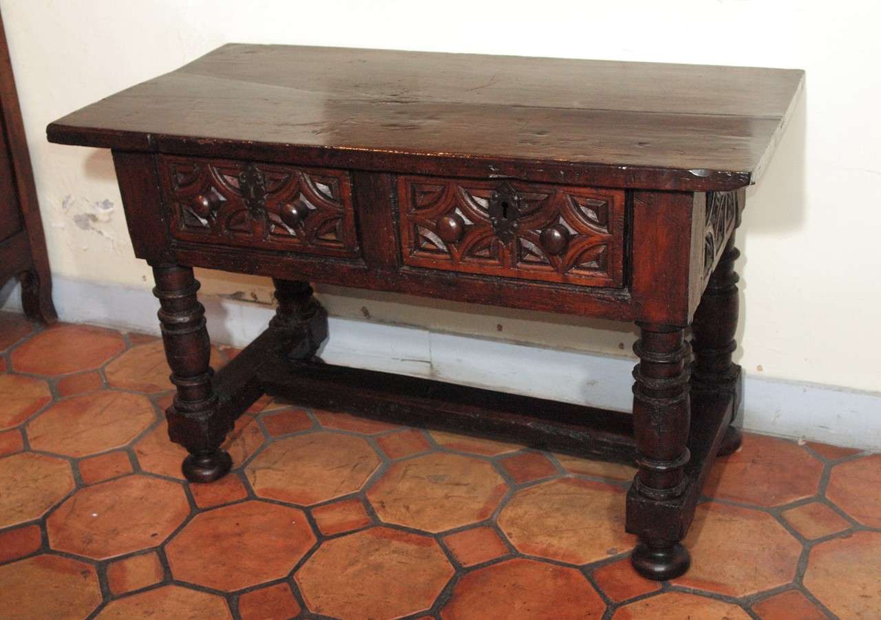 Italian late Renaissance walnut table with baluster legs, stretcher, and two drawers with carved decoration, circa 1680
