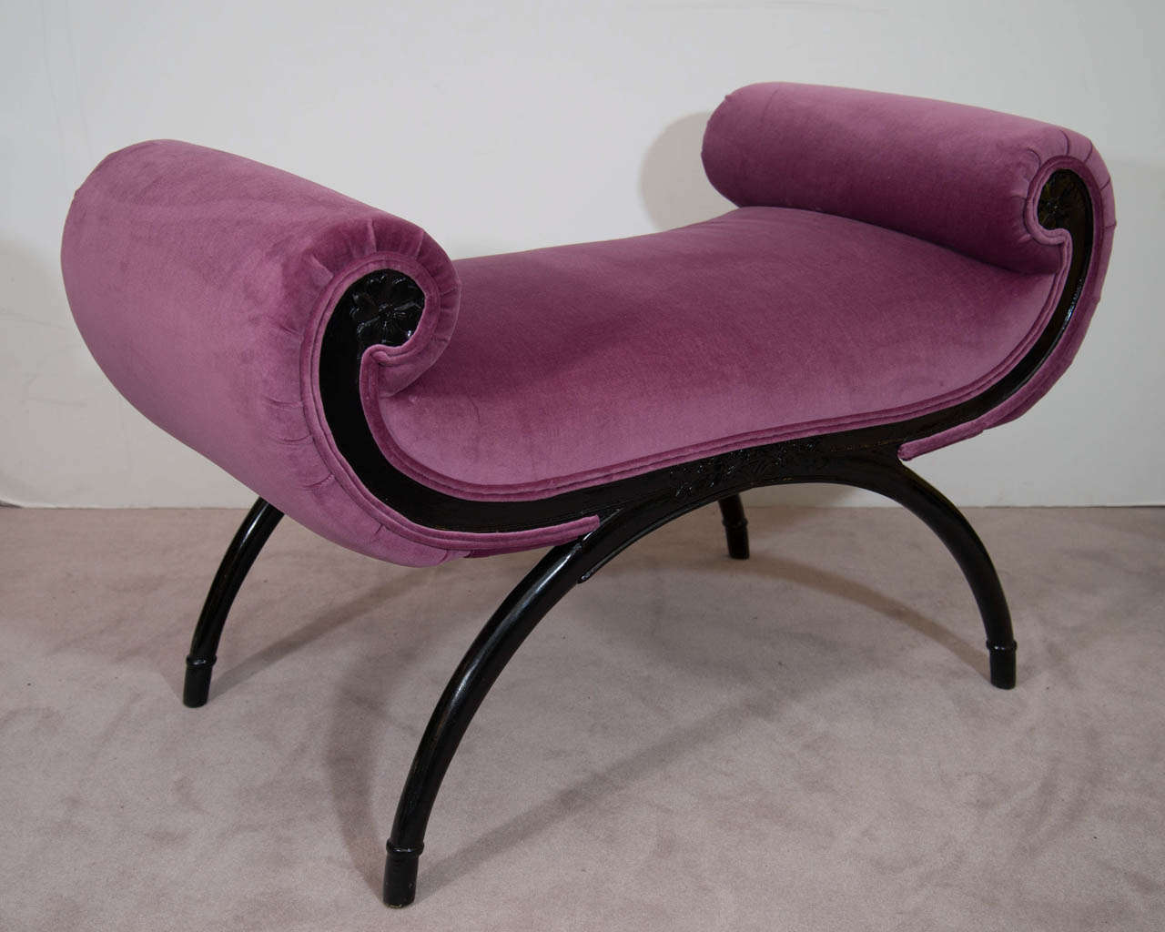 A  Hollywood Regency ebonized wood scroll arm bench newly reupholstered in an orchid velvet.