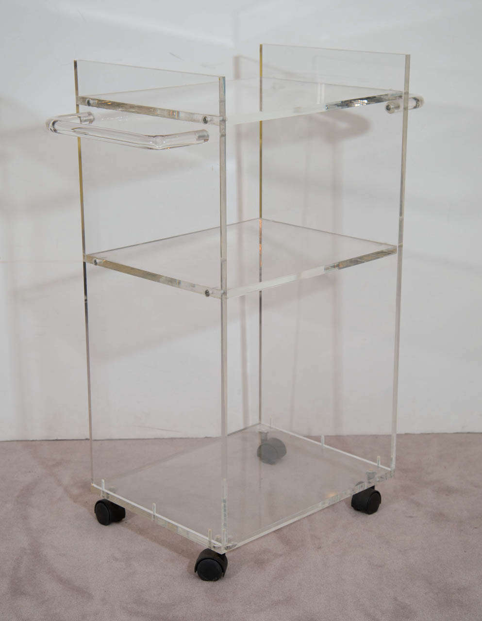 A 20th century three-tier, double-handled Lucite bar cart on casters.

Wear appropriate with use.  Some scratches to the surface.

Reduced from: $1,450