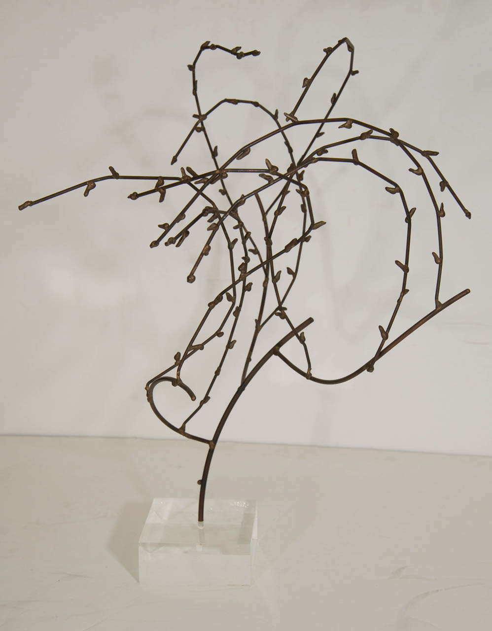 A 1970s willow sculpture made of mixed metal twigs mounted on a Lucite base. Good vintage condition with age appropriate wear, including minor scratches to the Lucite.