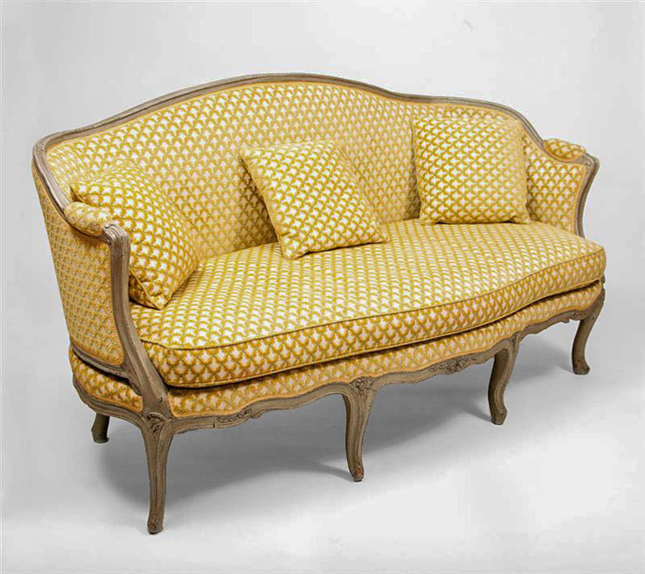 This fine sofa made in France circa 1750 is from the period of the reign of Louis XV. The carved beech wood frame is decorated with flowers and extensively modeled rails. The piece is curved at the back ( see image 10) and has a separate seat