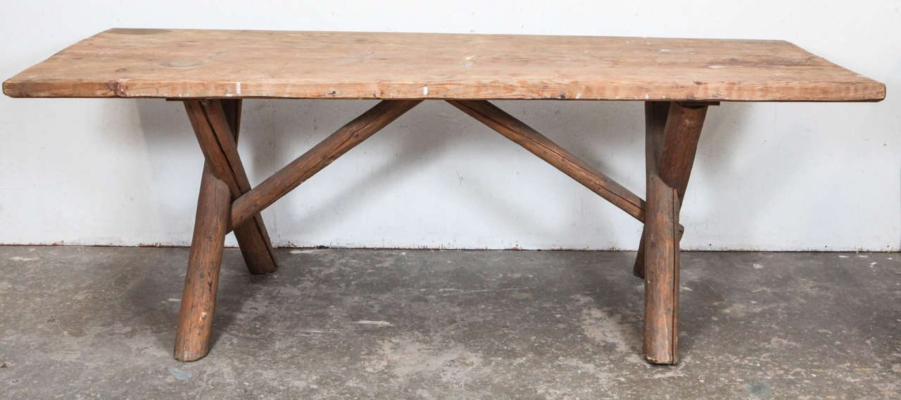 Rustic large dining table with crossed "log" legs.