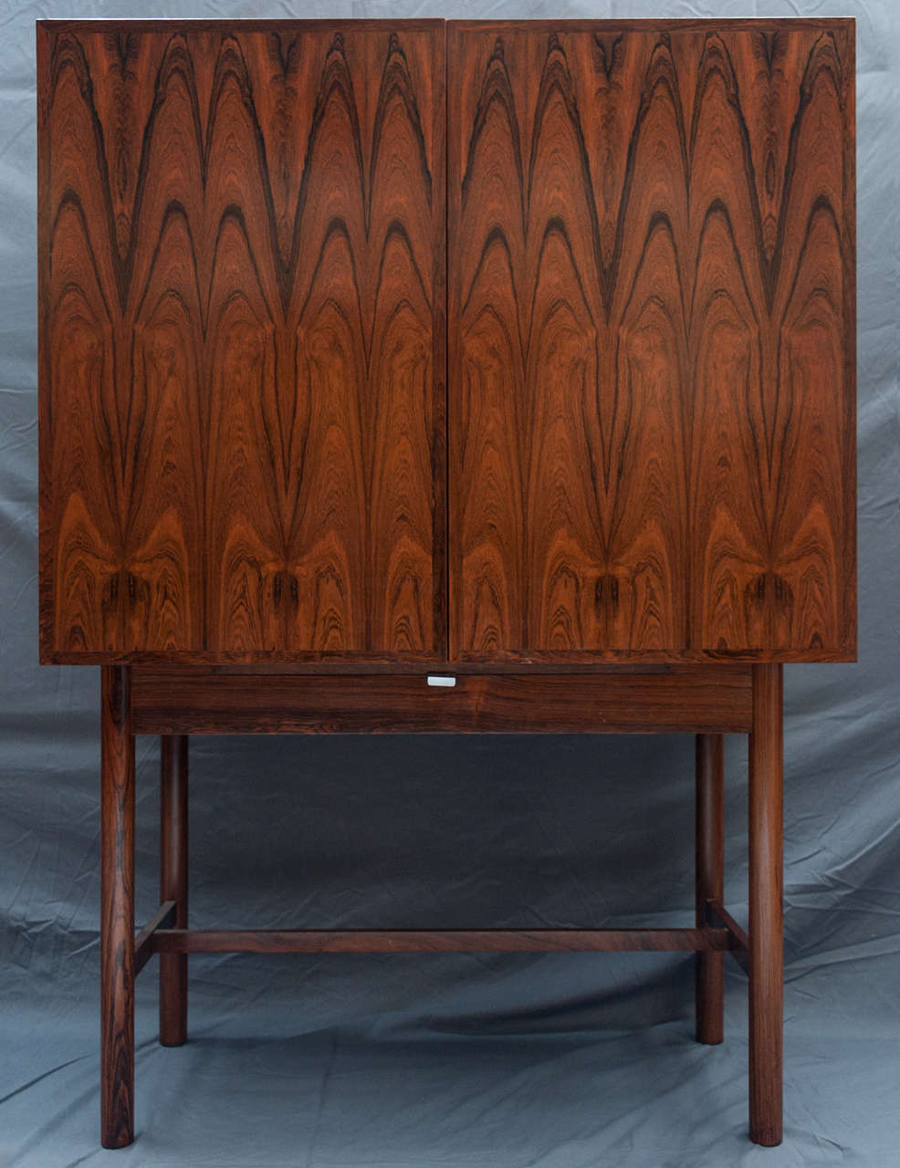 A fine Rosewood Drinks Cabinet by Robert Heritage for Archie Shine.
Fine veneers.
Opening to reveal an interior architecturally designed with drawer and shelving. The doors fitted with compartments for glasses.
The base with pull out