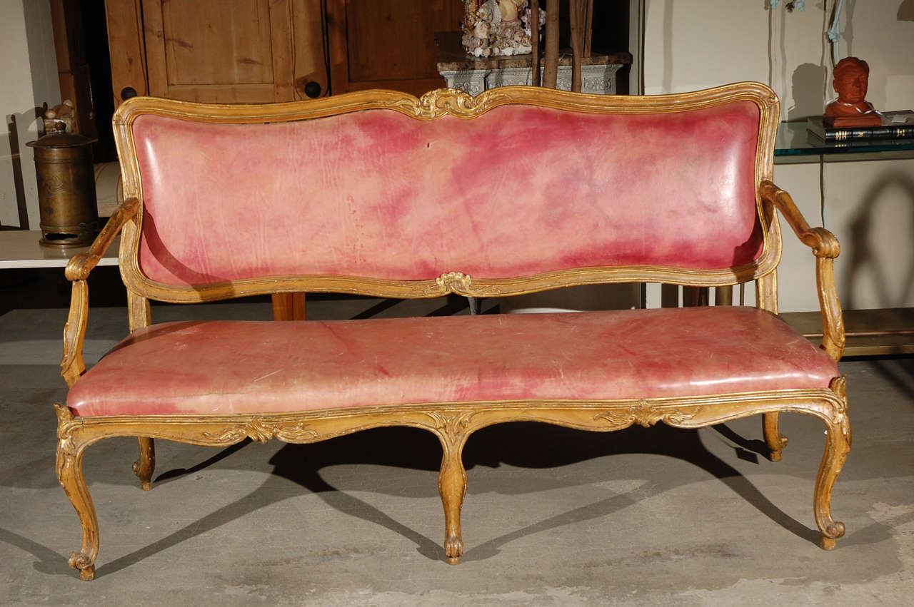 Italian giltwood canapé upholstered in pink leather, 18th century.