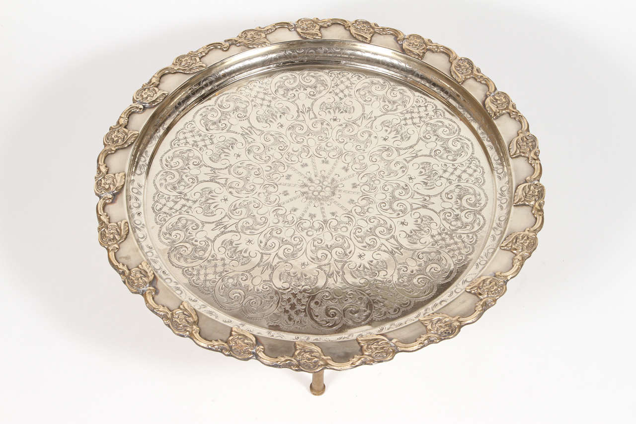 Gorgeous hand chased silver plated large Moroccan round serving tray on three removable legs. Typically used for tea service.
Hand carved amazing etching motif and silver finish.
George V style. Signed and numbered 444

Mosaik provides Antiques,