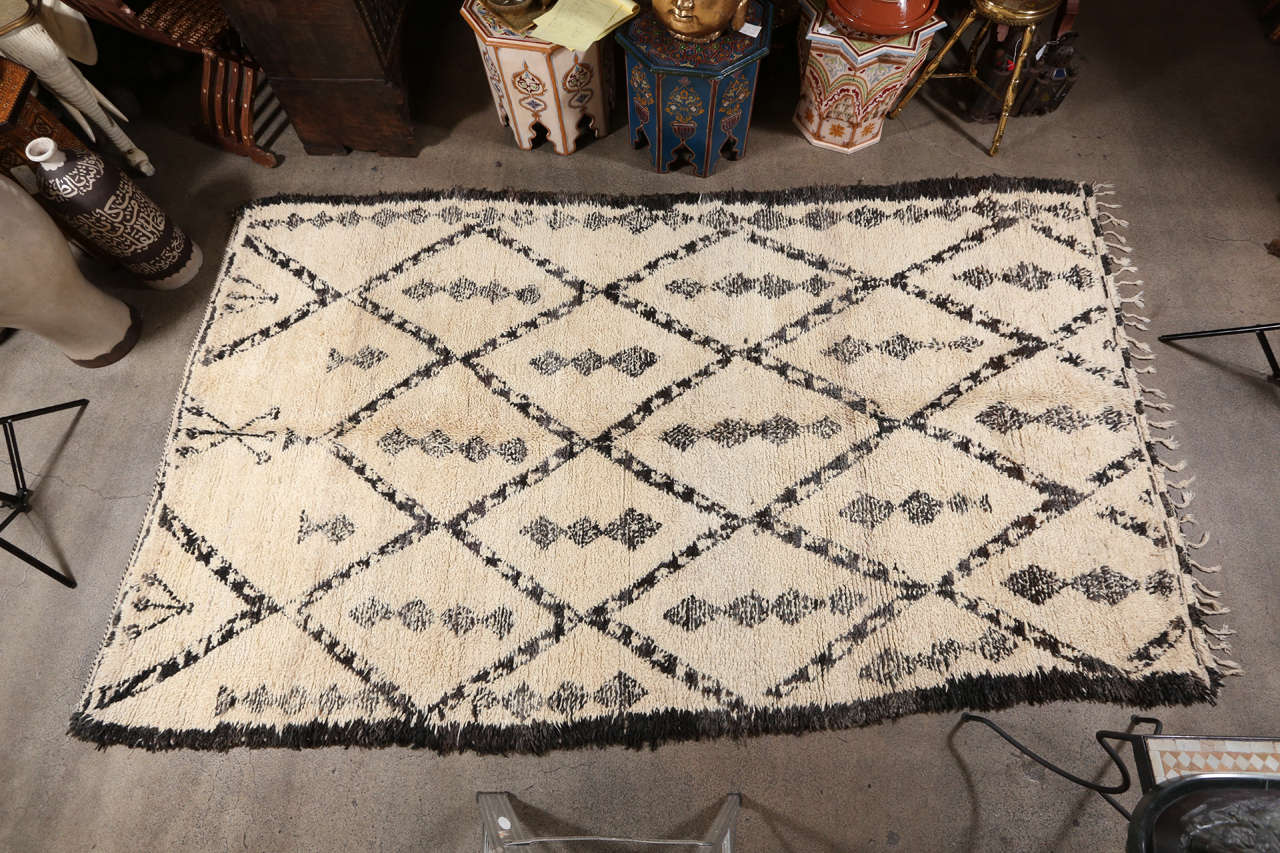 Moroccan vintage tribal rug from Beni Oaurain.
Un-dyed ivory and black organic wool.
Geometrical diamond shape lattice design in black on ivory cream background.

Mosaik provides Antiques, Moorish Style, Spanish, African, Islamic Art, Arabian,
