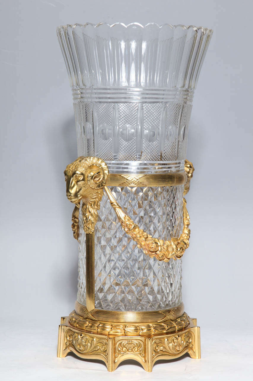 A Monumental French Louis XVI style cut and hand etched crystal vase with bronze dore mounts. The ram's heads and floral swags as well as the cast and chased base are typical of the design elements popular in the 2nd Empire and Louis XVI period. The