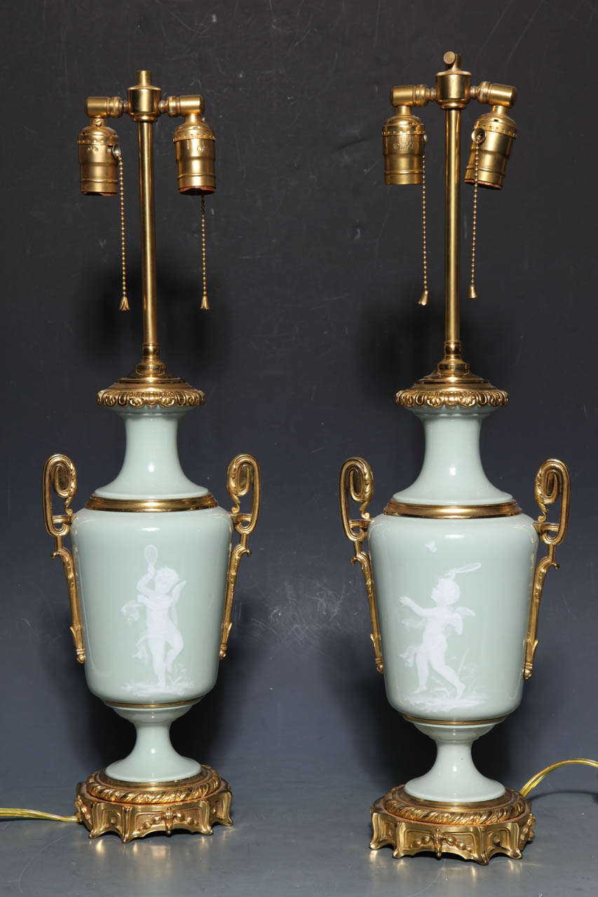 A Magnificent pair of 'pate sur pate' (paste on paste) decorated vases with lavish gilt bronze mounts. This method of decoration was perfected by Marc Louis Solon at Sevres circa 1850. He later moved to England where under his direction Minton's