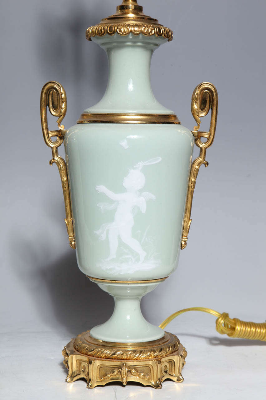Pair Ormolu Mounted 'Pate sur Pate' Porcelain Lamps Depicting Cupids In Excellent Condition For Sale In New York, NY