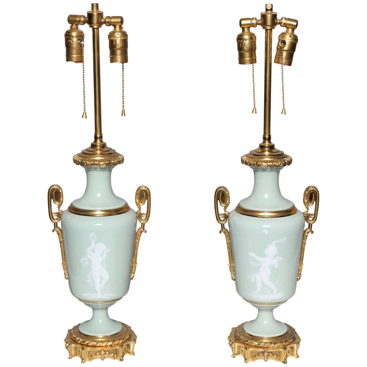 Paire de lampes en porcelaine « Pate sur Pate » montées en bronze doré représentant des Cupidons
