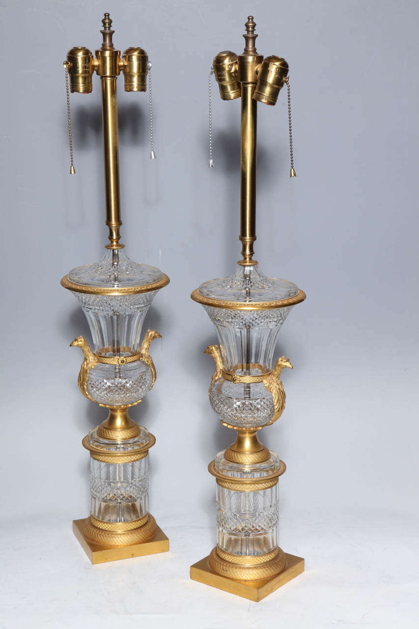 An exquisite pair of very fine Antique French Louis XVI style hand diamond cut crystal and Dore bronze two handled covered urns/lamps. The campagna form dates back to the Greco Roman era and the shape remains popular today.The Neoclassical bronze