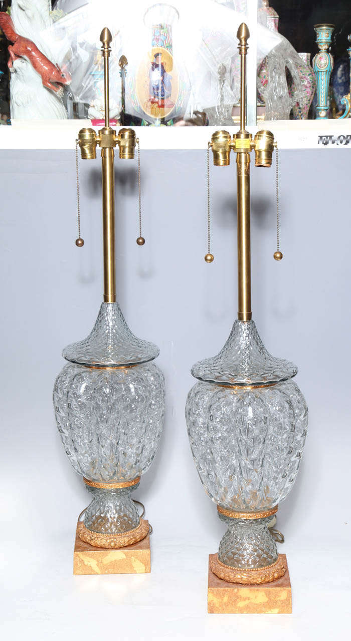 A monumental pair of murano glass vases wired as lamps with gilt bronze mounts. On a small island in the Venetian lagoon, Murano, artists make magic with common materials and great artistry. While it is believed that glass making started in the 8th