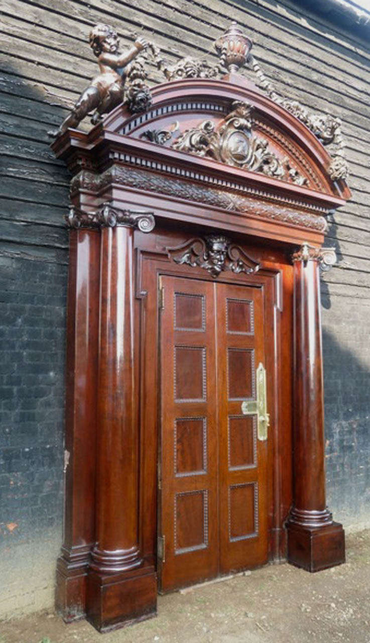 The eight-panelled double-moulded finely raised and fielded door is made from solid mahogany with its original brass lockset and fingerplates, Ionic columns to the doorcase below a pulvinated frieze of carved laurel, an arched overdoor and dentil