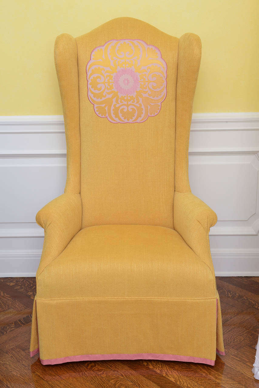 Each wing chair with exaggerated Hollywood Regency proportions; daffodil yellow linen upholstery embellished with silk floral appliqués, see photos of back side.
