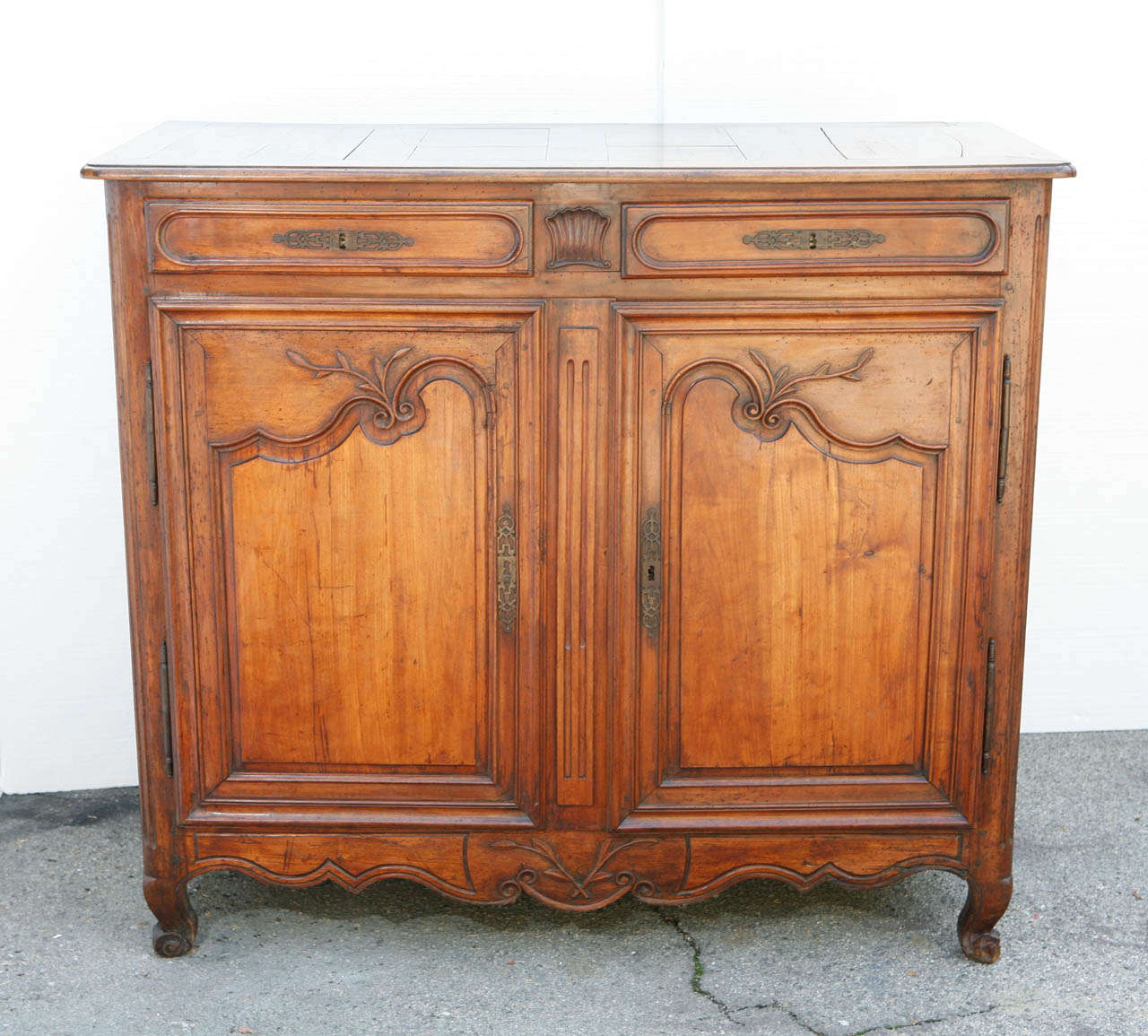 French provincial buffet/sideboard with 2 drawers and 2 doors.
All bench made in hand carved fruitwood. Original lock and replacement key. Beautiful, rich patina.Very good, small cutout on inner shelf, all original hardware.
Fruitwood exterior