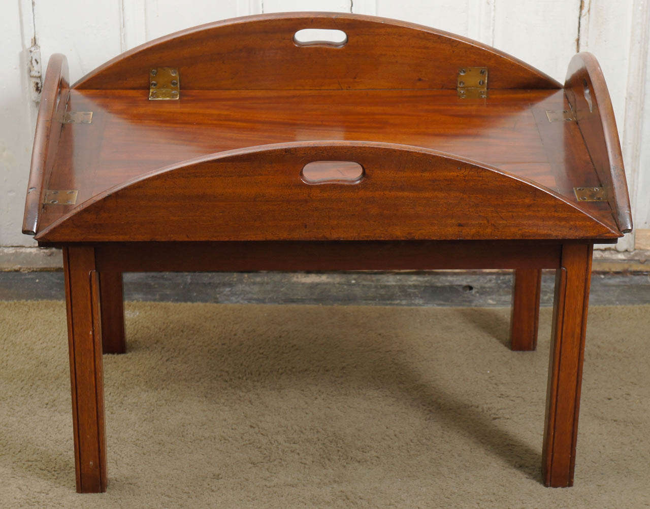 This very fine 19th century mahogany tray made circa 1840 set upon a later coffee table stand is of the very best quality. The mahogany is first choice and retains a great degree of its color and patina set with heavy brass hinges. The grain is