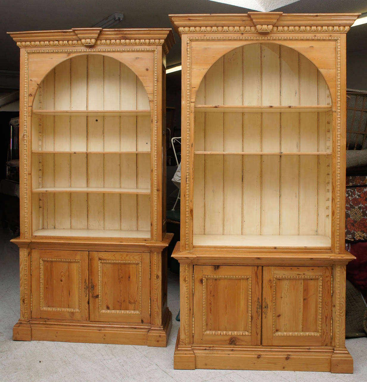 This fine pair of bookcases with deep & crisply carved egg and dart molding  on the cornice ,doors and shelf openings are made from old architectural pine lumber. Constructed in the George III style the bookcases have three adjustable shelves each