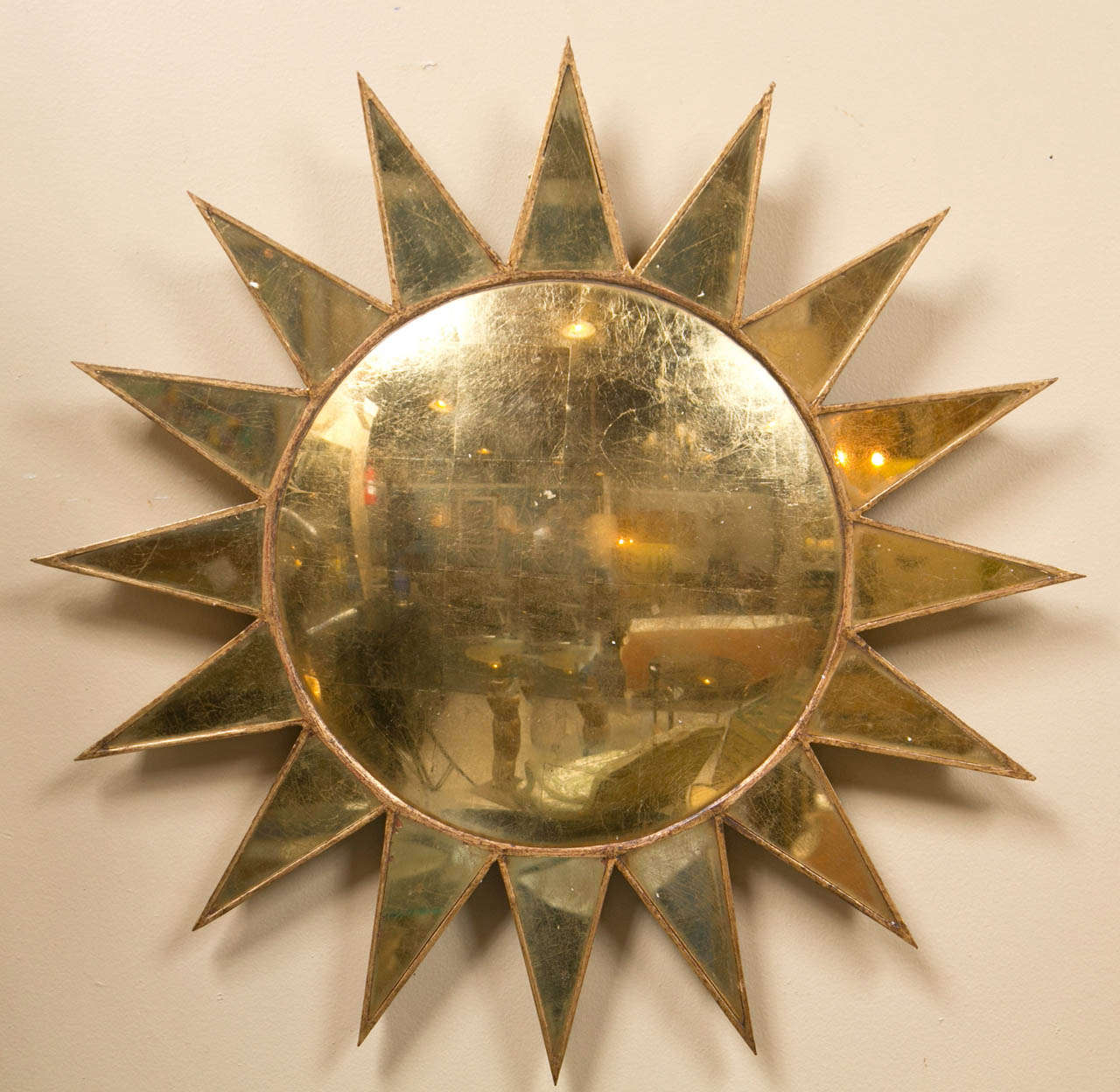 Pair of decorative mirrors in the sunburst shape, each having wood backing and gold-leafed eglomise glass. The central convex mirror framed with 16 triangular sun rays. 

Depth from the wall 1 1/4 Inches