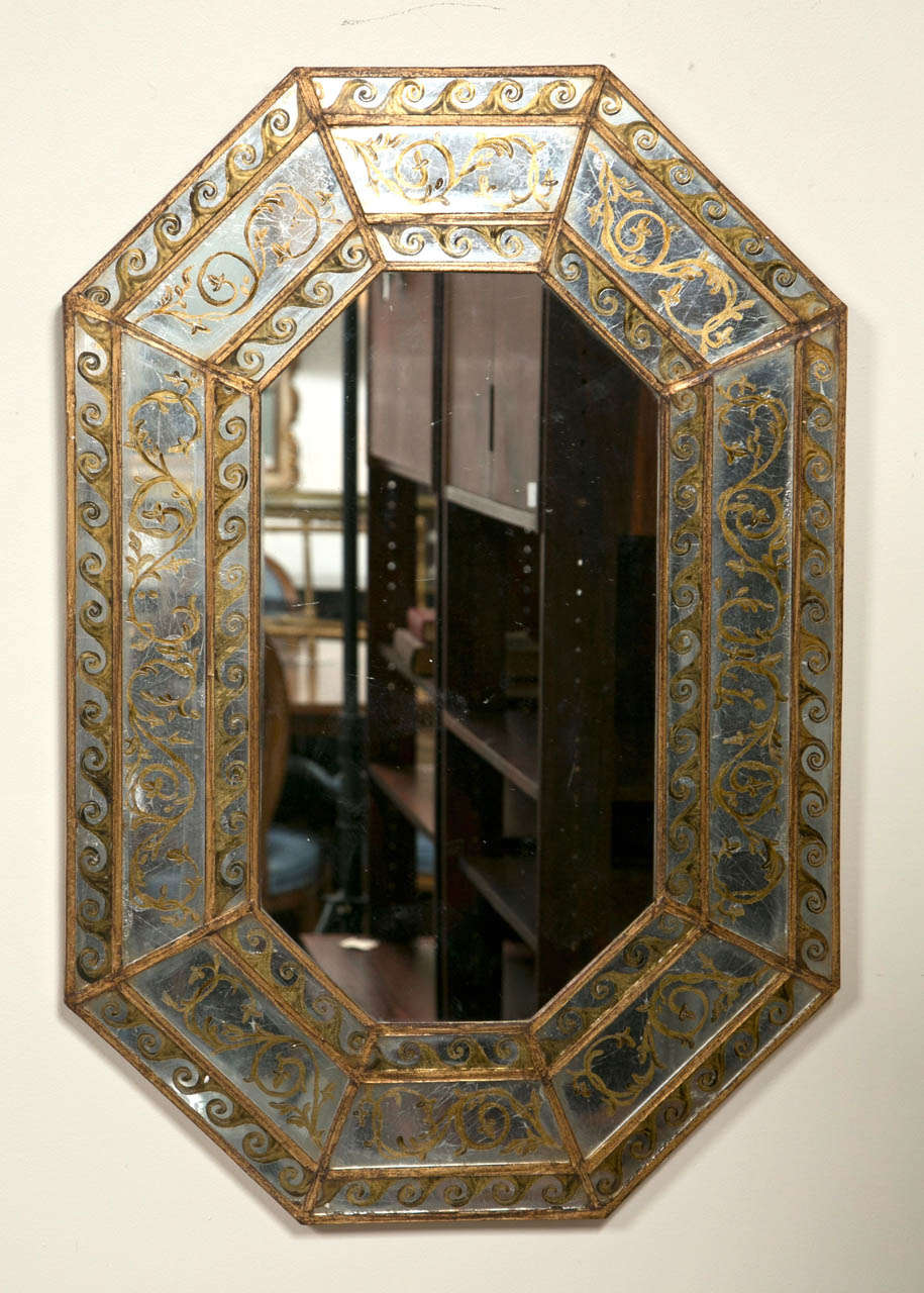 A fine pair of custom quality octagonal shaped Eglomise mirrors. The triple reverse painted borders framing out a central mirror. In the manner of Maison Jansen.