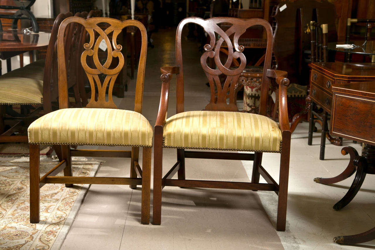 Set of 10 English George I style dining chairs, circa 1950s, the set consists of 2 armchairs and 8 side chairs, the scrolled back splat, padded seat, raised on squared legs with an H stretcher. These fine pretzel back dining chairs made by the Baker