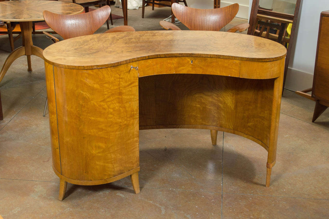 A gorgeous Kidney shaped desk of Elm, with storage behind the door.
Locking drawer and locking door.

Amazing grain pattern on ALL sides of this desk.

Front modesty panel that accentuates the curves at the front of the desk.