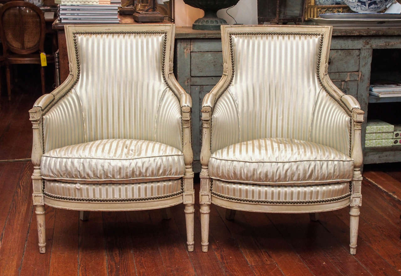 Pair of 19th century Directoire style painted bergères in a cream color. Needs new upholstery.