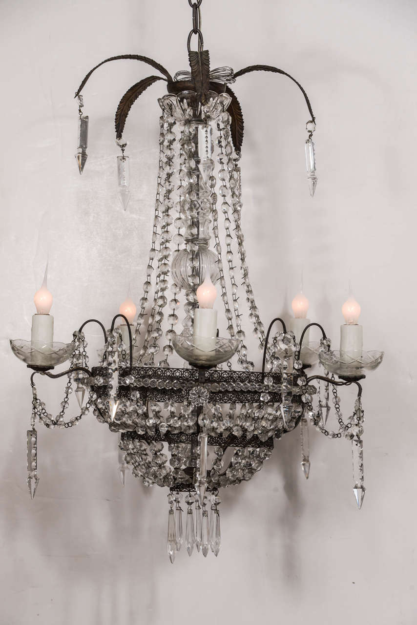Pierced tole Italian chandelier decorated in crystal and glass prisms, Dates to late 19th century. Chandelier fabricated from iron and tole and decorated in crystal pendants and chains of crystal prisms. Newly-wired for use within the USA with five