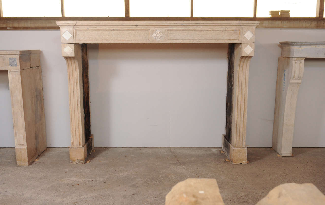 An early 19th century French Neoclassical carved limestone (Pierre de Bourgogne) fireplace / mantel piece.

Measurements: 127 cm. high x 162 cm. wide x 57.5 cm. deep (incl. side panels; the top: 30 cm. deep); fire opening: 109 cm. high x 136 cm.