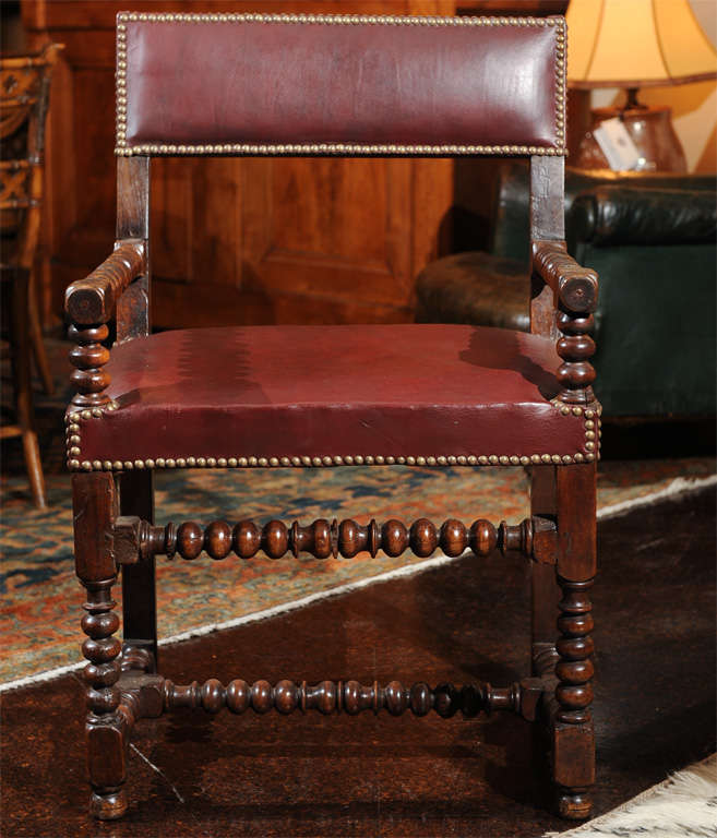 Bobbin turned walnut armchair with red leather upholstery and nailhead trim, French, circa 1800.