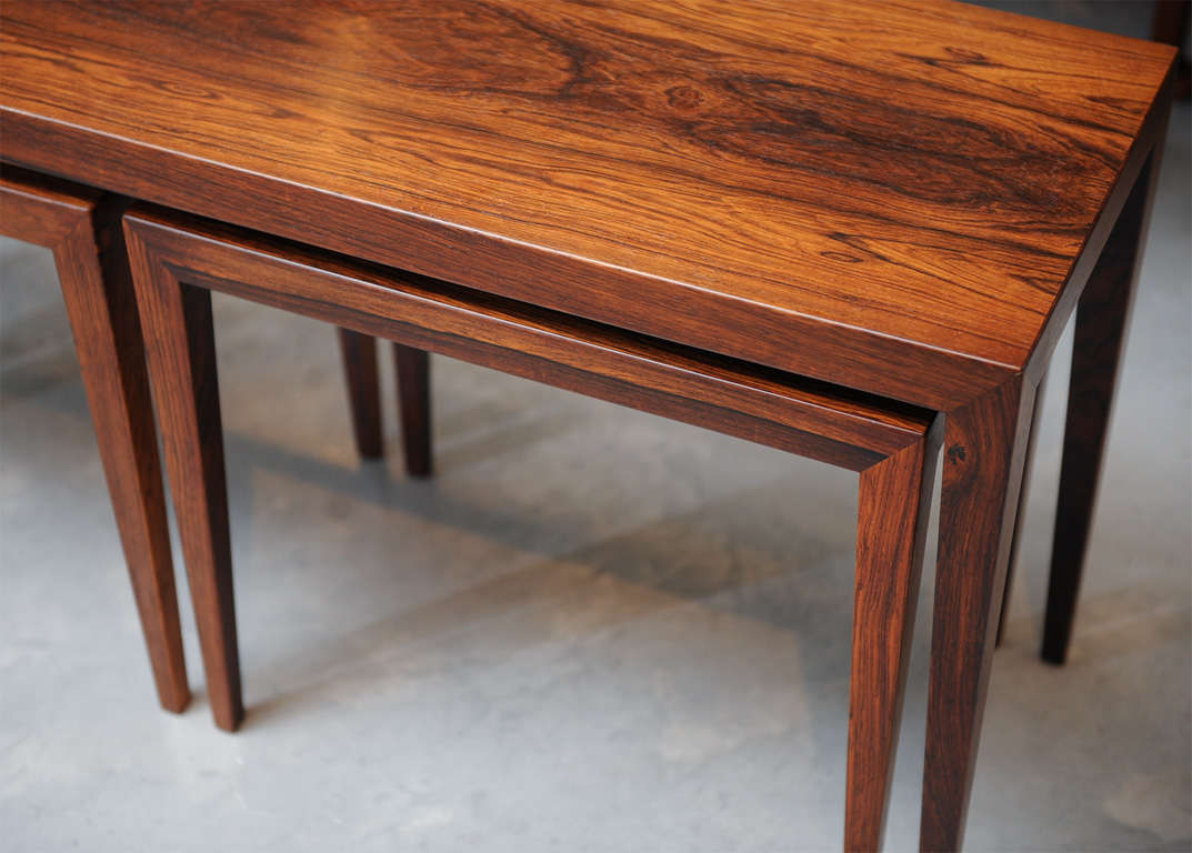 A set of three rosewood nesting tables, one long and the other 2 with the same dimensions.