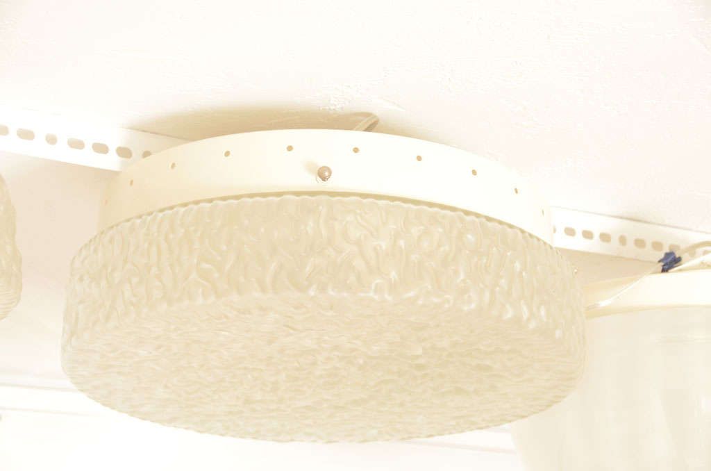 Rippled textured glass ceiling fixture with an opaque finish.
