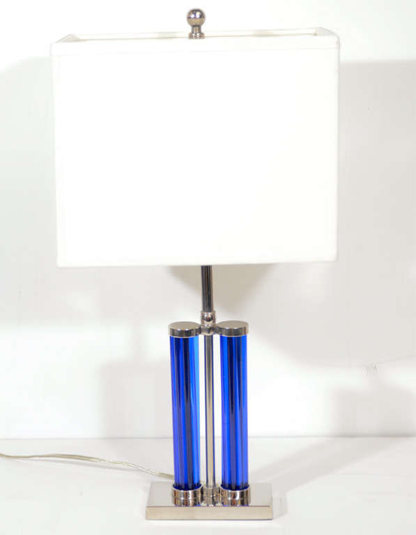 This gorgeous lamp features chromed fittings supporting columns of colbalt blue glass rods. This lamp exemplifies the Machine Age movements influence on Art Deco in America. Newly Rewired with custom shade and fitting for two light bulbs..