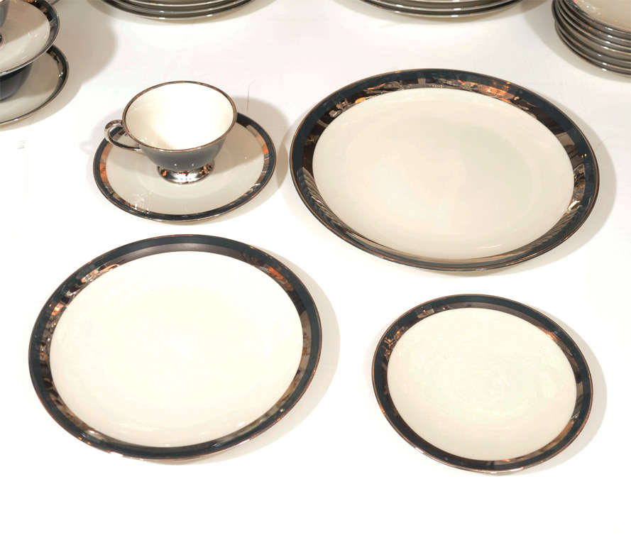 This stunning set features concentric rings of 24k white gold with graphite  bordering the creme colored china. The set has eight dinner plates,8 salad Plates,8 smaller plates and 8 cups and saucers.Dinner plate is 11 inches diameter