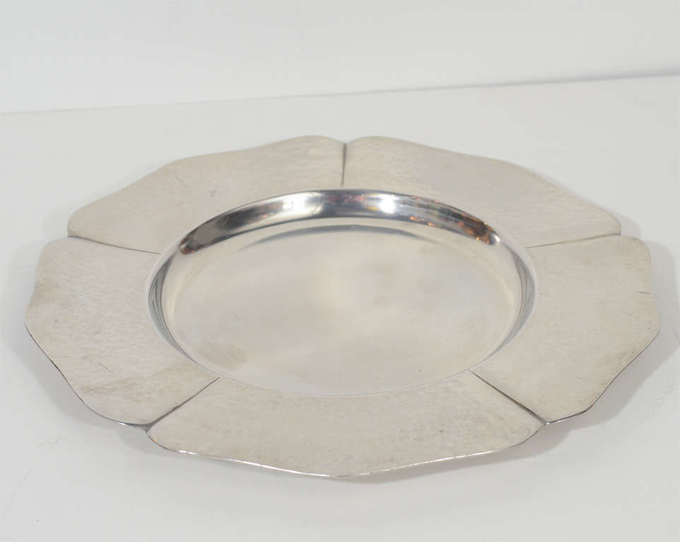 This set of four hand wrought pewter charger plates are by Porter Blanchard the reknowned designer of exquisite sterling and metal ware. He is now deceased and his works are in collections and museums worldwide.The plates are signed Hand Wrought by