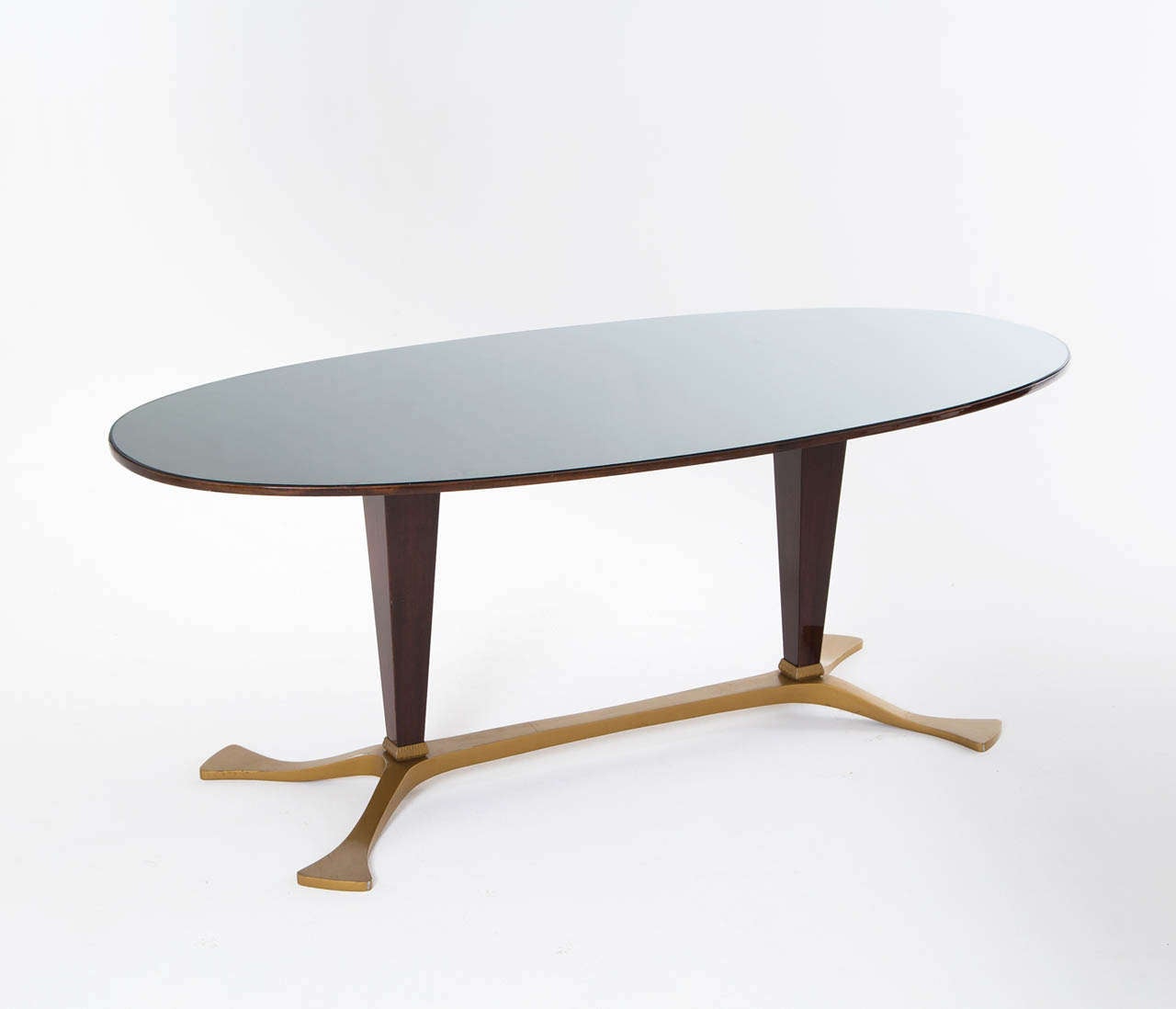 An early Osvaldo Borsani Table, oval shaped, with a elaborately veneered high gloss top and a thin layer of glass, creating beautiful refractions in dark and light, standing on a rosewood veneered / brass colored base.