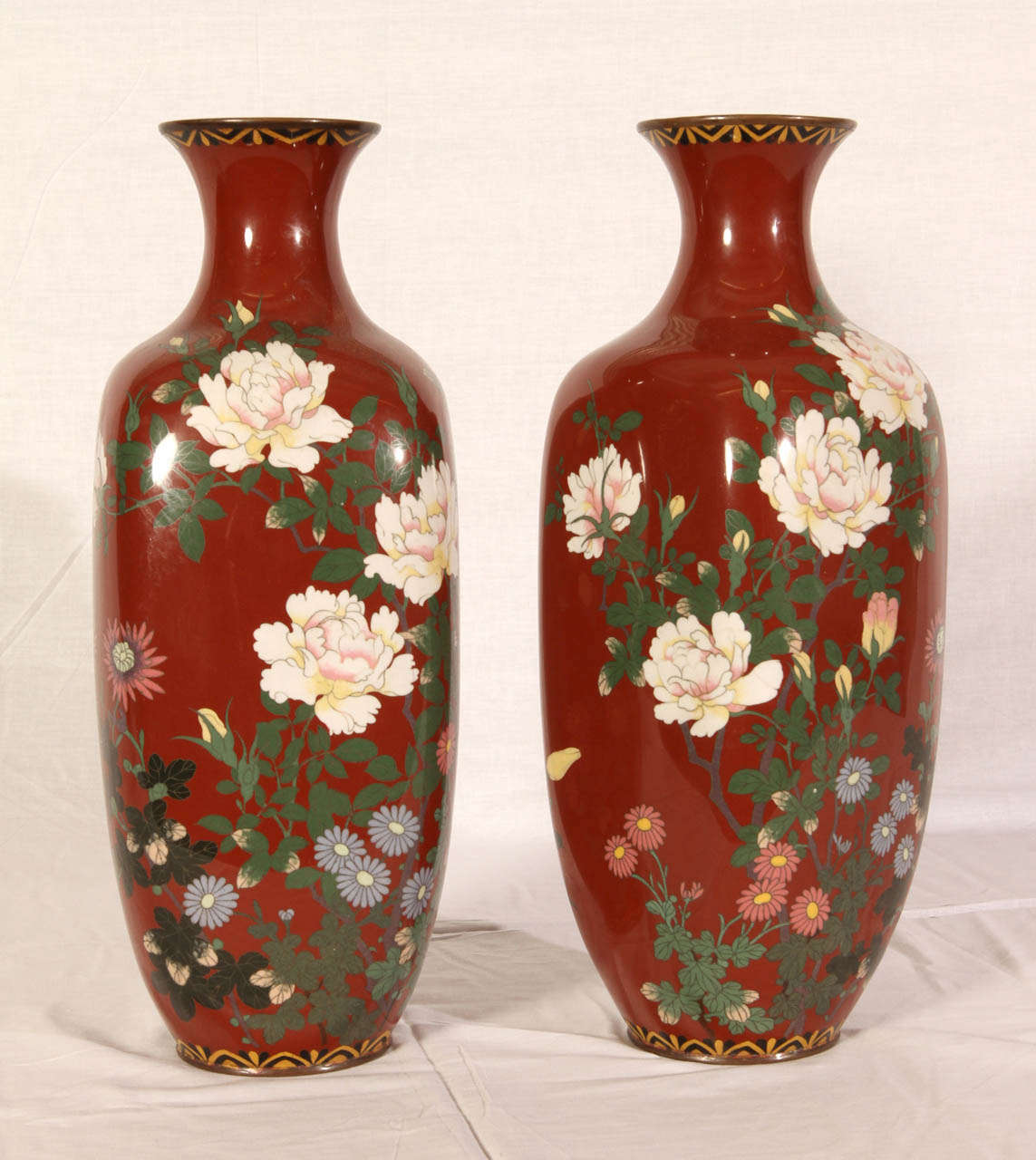 Pair of early 20th Century Japanese vases. Polychrome porcelain and cloisonne enamel with a flower decor. Very good condition. Normal wear consistent with age and use.